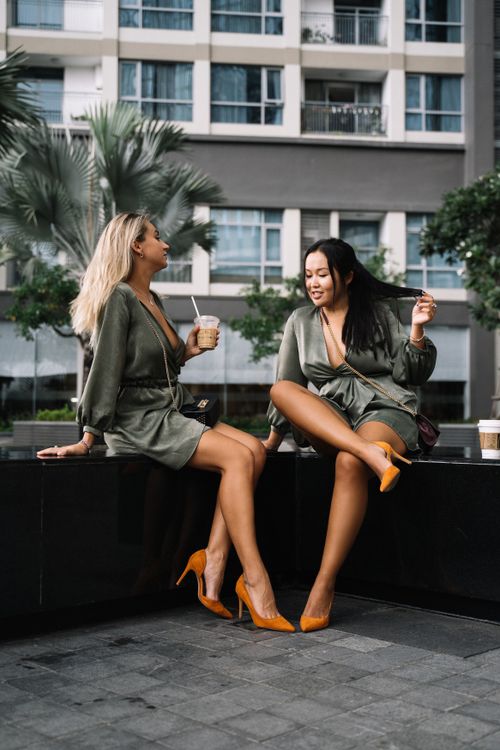 Free Two women enjoying leisure time in urban setting wearing matching outfits. Stock Photo
