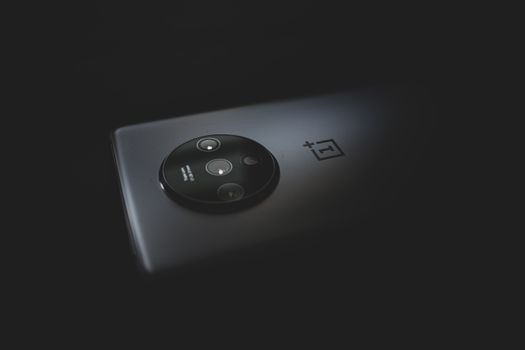 Detailed close-up of a modern smartphone camera against a dark background.