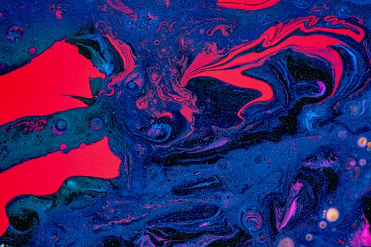 Dynamic abstract artwork with vivid blue and red swirling paint patterns creating a cosmic effect.