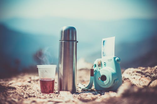 An Instant Camera beside a Vacuum Flask