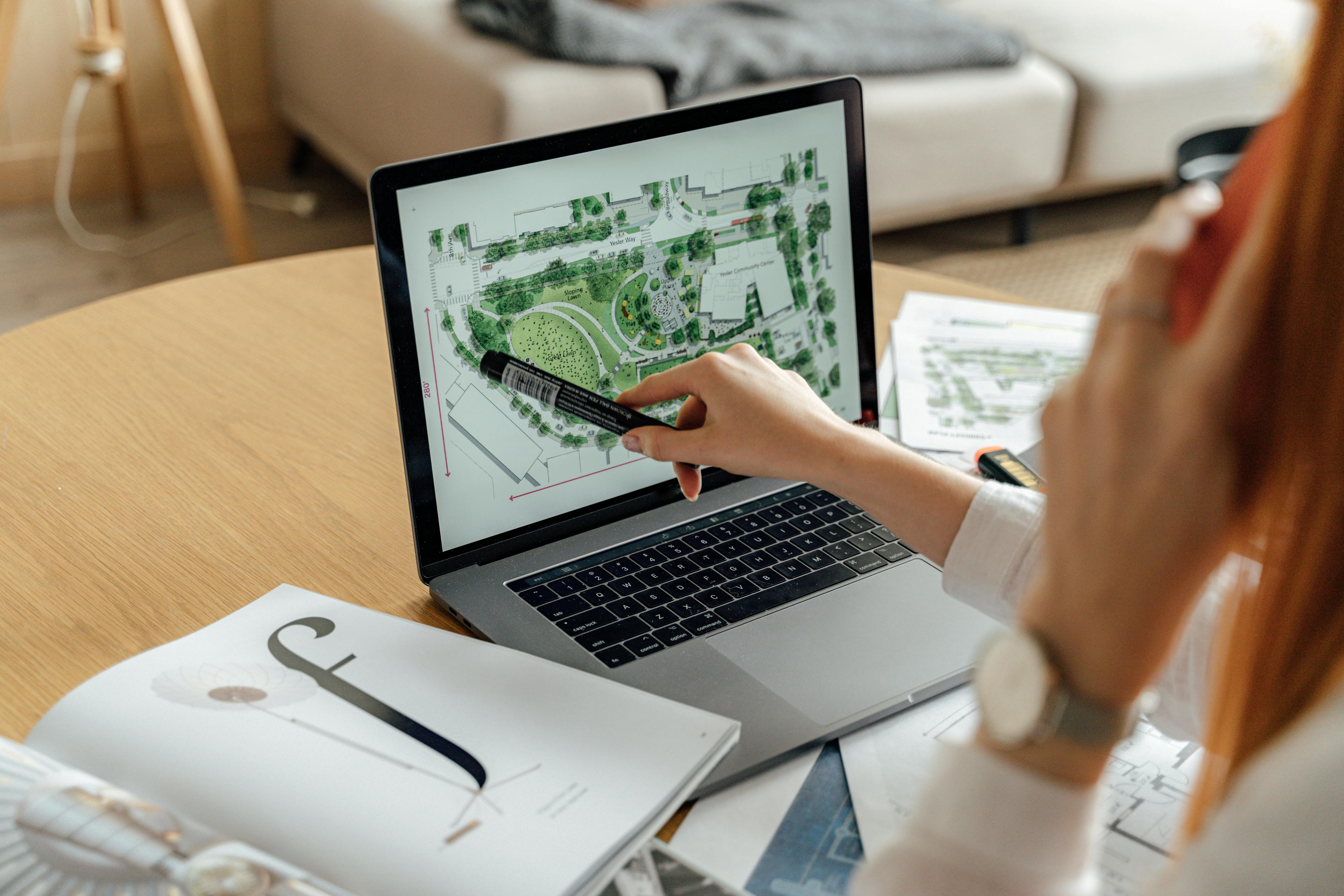 person writing on white paper on macbook pro