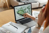 建筑师在笔记本电脑上审查景观设计，增强家庭办公室的建筑项目