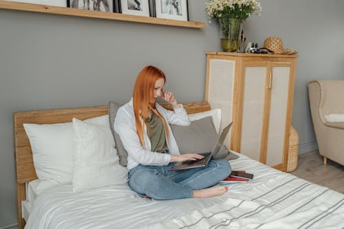 Foto profissional grátis de cama, computador portátil, digitando