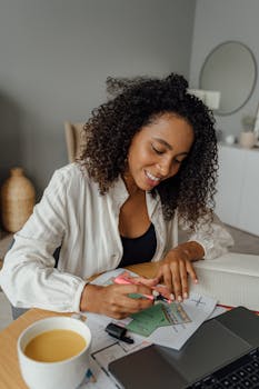 一位女士在家中面带微笑，用彩色笔和咖啡创造性地构思设计想法