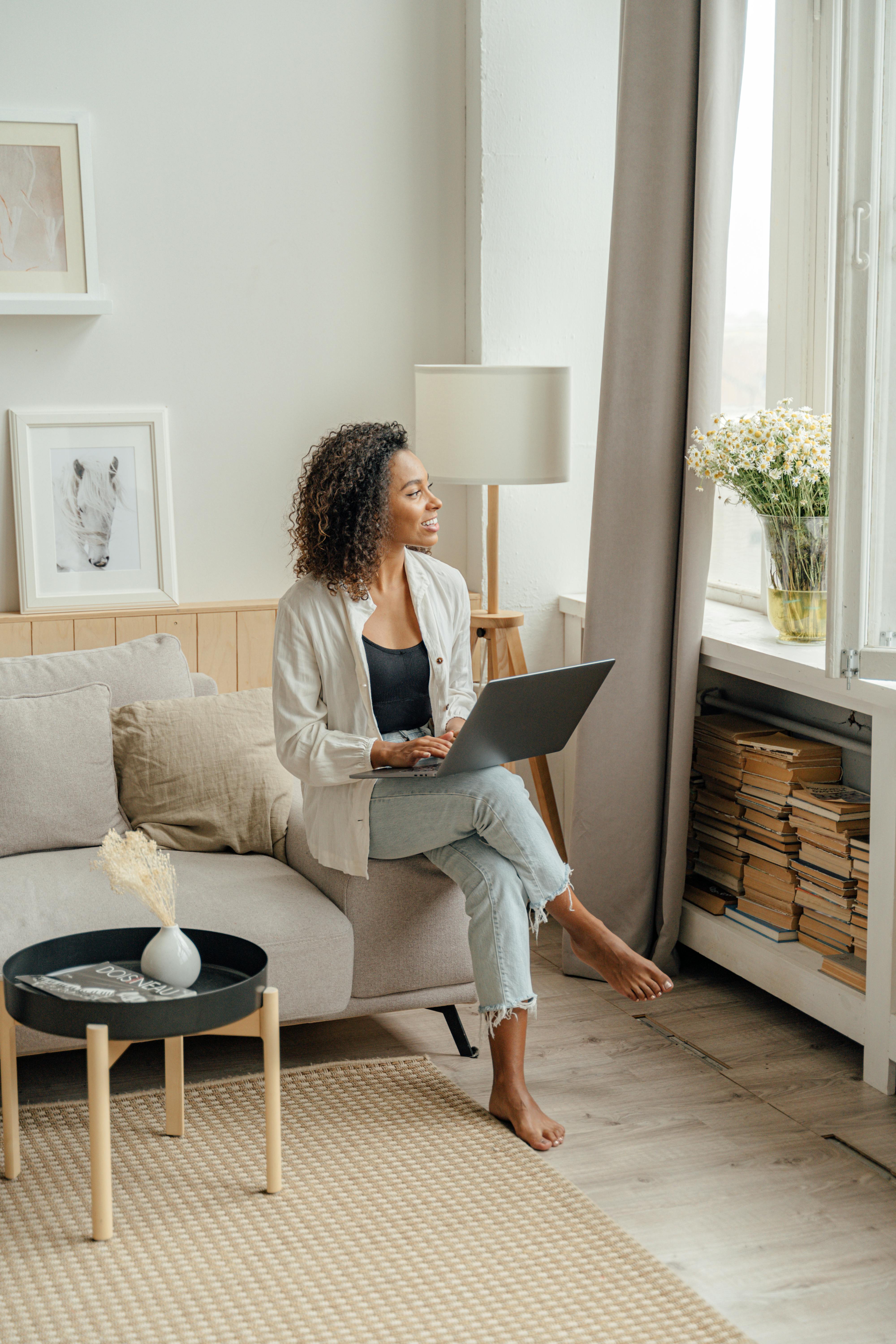 a woman looking at the window while sitting on sofa