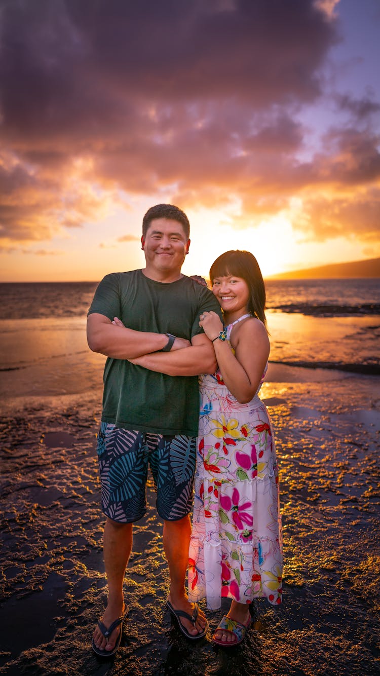 Joyful Asian Couple Hugging And Standing On Sunset Beach