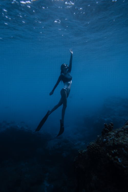 Anonieme Geschikte Vrouw Die In Blauwe Oceaan Zwemt