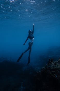 A captivating image of a swimmer exploring the deep blue ocean underwater, embracing the serenity of marine life.