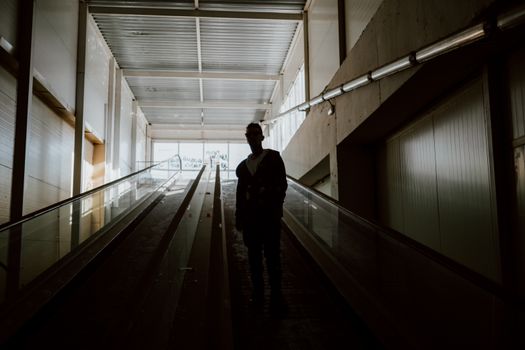 现代建筑室内，一个人站在自动扶梯上的剪影