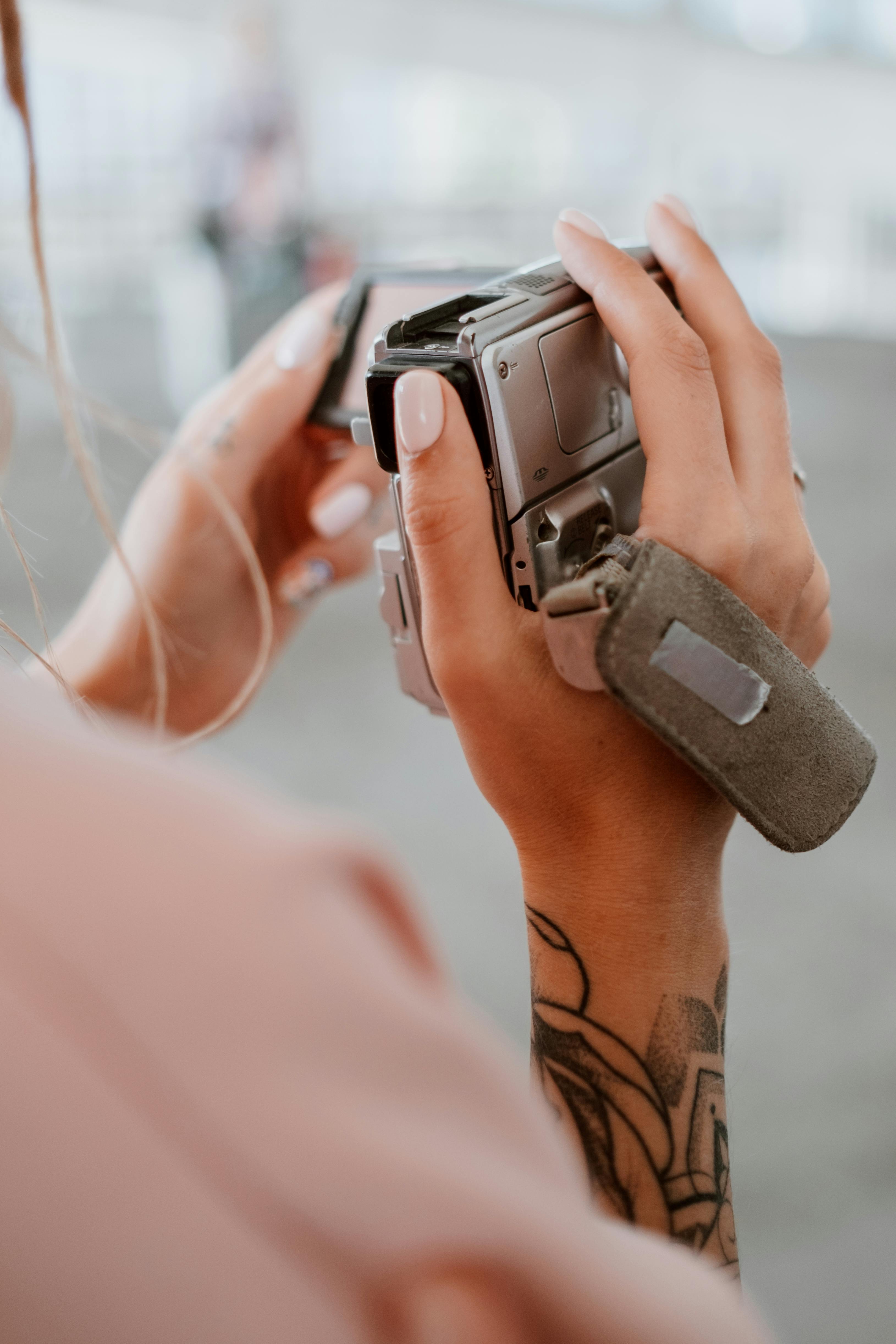 person holding a silver camera