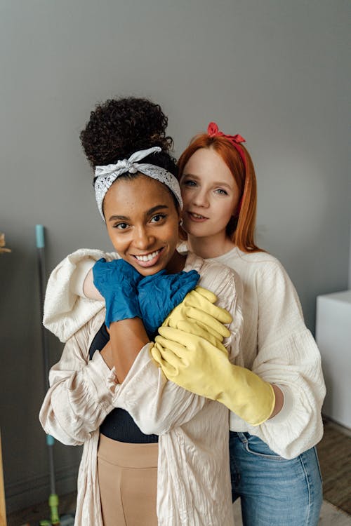 A Happy Female Couple Wearing Gloves