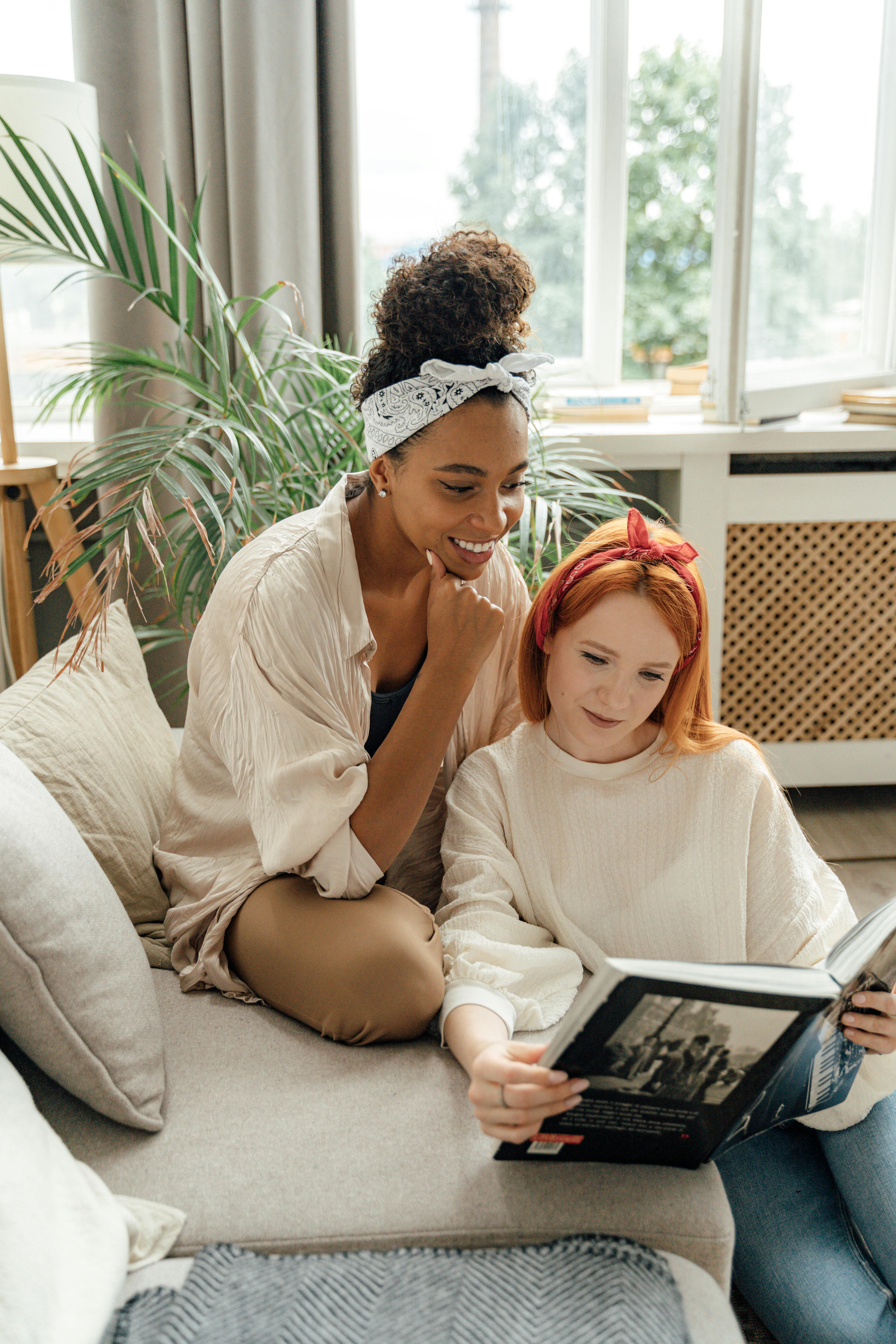 woman in white shirt sitting on womans lap