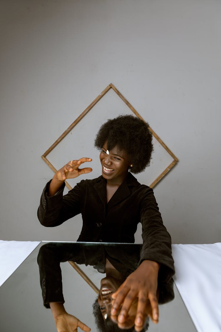 Woman In Black Blazer Smiling With Mirror In The Table 