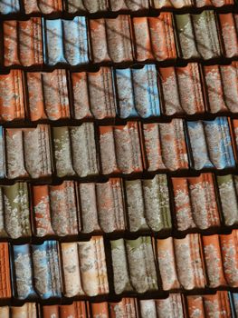 Close-up of colorful weathered roof tiles with textured surfaces.