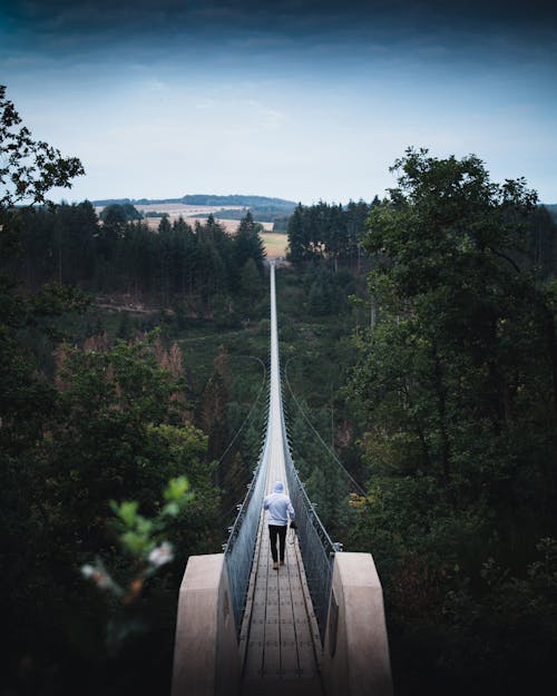 Person in Hoodie Walking on Bridge 