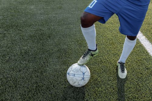 Free Close-up of a player controlling a soccer ball on a grass field. Stock Photo