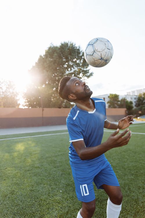 Free Young athlete practicing soccer ball control on a sunny field. Stock Photo