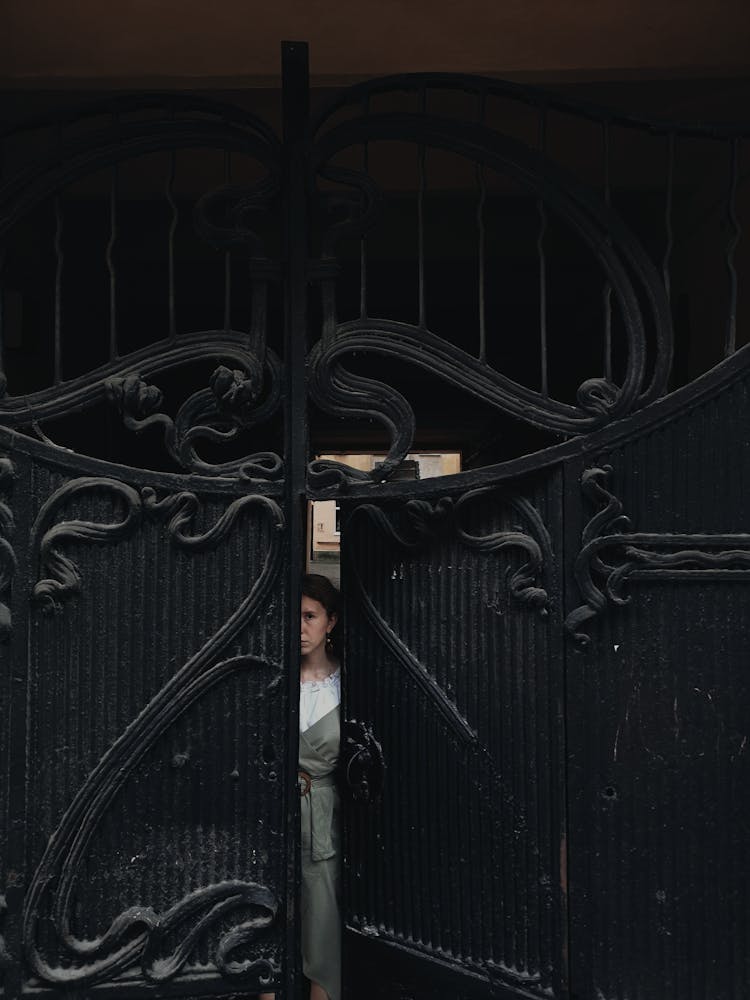 Woman Peeping Behind A Metal Gate 