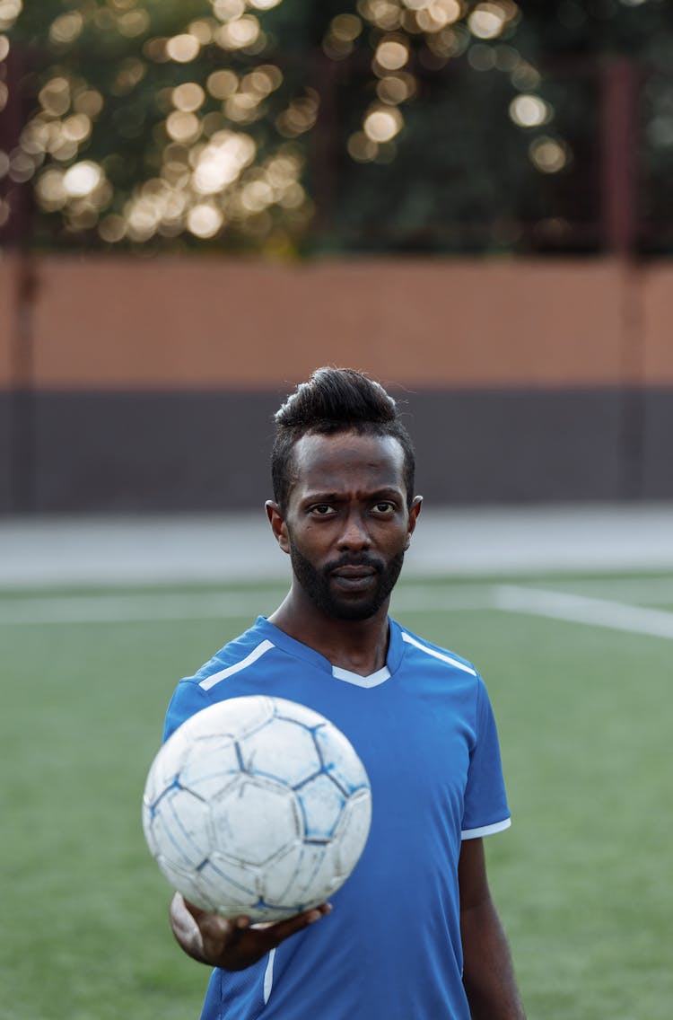Man In Blue Soccer Jersey Holding A Ball 