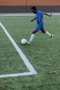 Man in Blue Shirt and Blue Shorts Playing Soccer on Green Grass Field