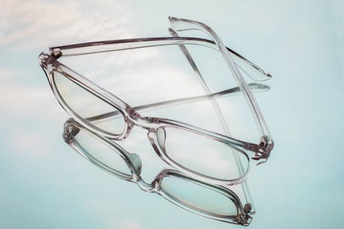 From above of glasses for correcting bad eyesight placed on white mirrored surface