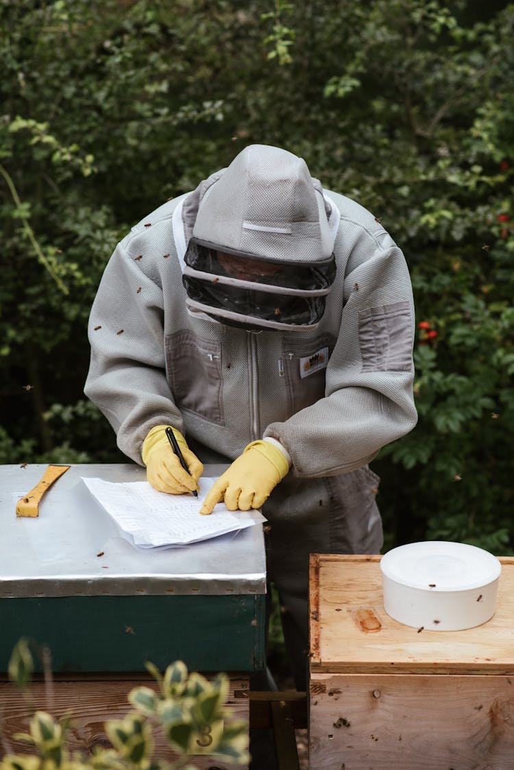 Anonymous Beekeeper Taking Notes In Garden