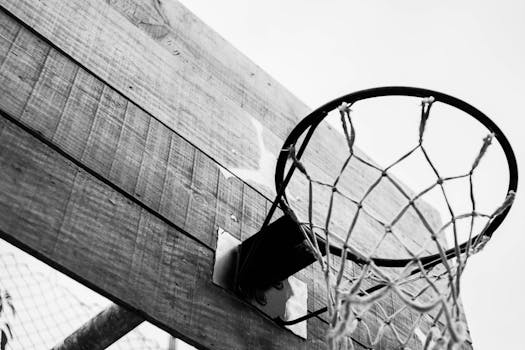 Black and white of basketball hoop hanging on wooden board located on sports ground on street