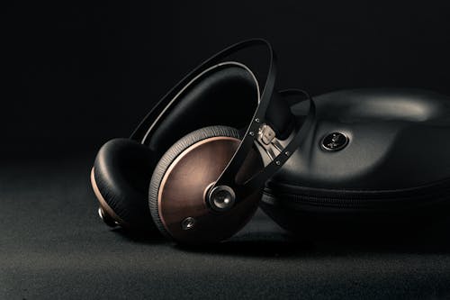 Modern headphones with box placed on black surface