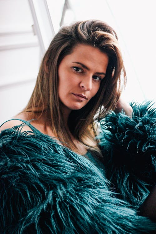A Woman in Green Fur Coat Looking with a Serious Face