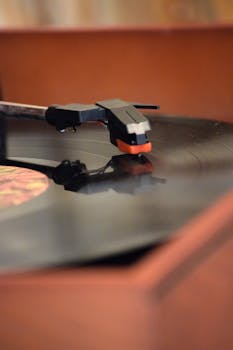 A retro turntable playing a classic vinyl record with a focus on the tonearm and needle, evoking nostalgia.