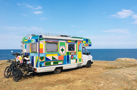 Vibrant camper parked by the sea in Tyulenovo, Bulgaria, under a clear sky.