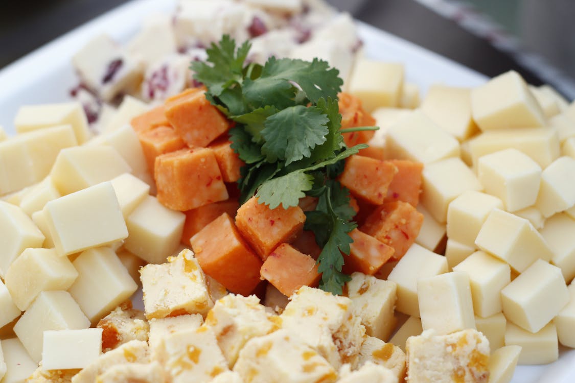 Free Assorted Cheese Sliced on White Plate Stock Photo