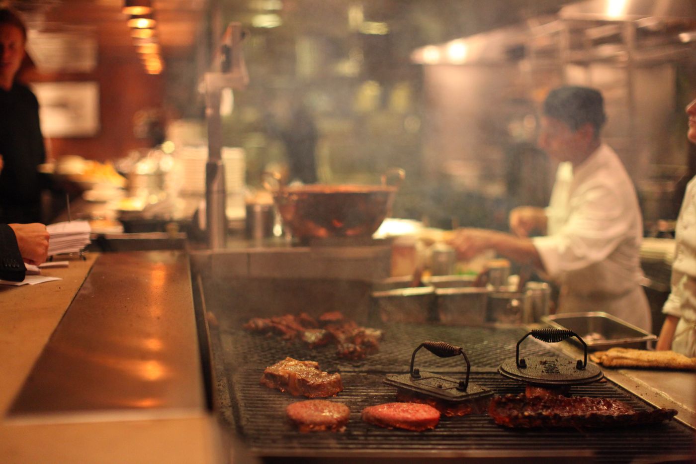 Chefs grilling and cooking in a professional restaurant kitchen