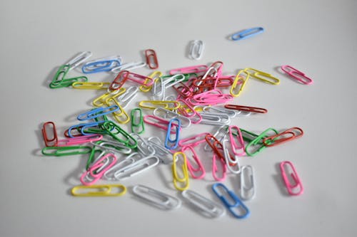 Multicolored Paperclips on a White Surface