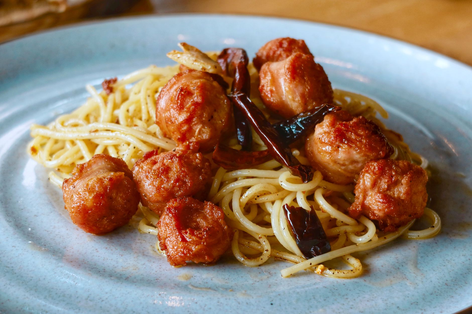 Bowl of creamy mac and cheese with golden sausage meatballs