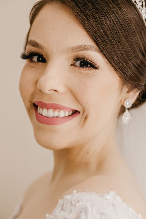Free Happy young fiancee with makeup and dark hair tied up looking at camera on beige background Stock Photo