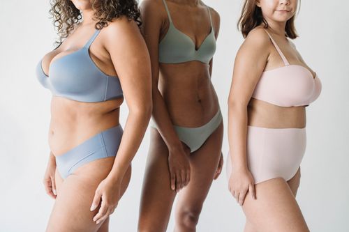 Free Three diverse women modeling stylish bras and panties on a white background. Stock Photo