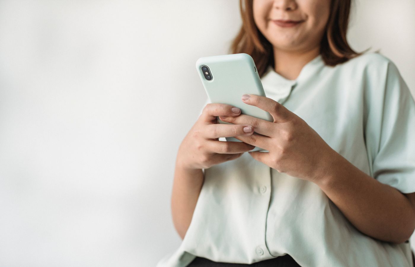 Close-up of a woman using a smartphone indoors with ample copy space.