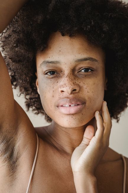 Close-up portrait of a young woman with beautiful freckles, showcasing natural beauty in a studio setting.