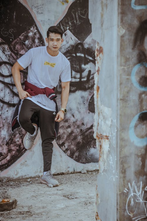 Young man standing near graffiti wall · Free Stock Photo
