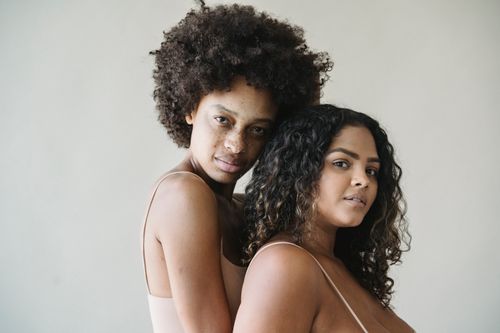 Free Two women embracing in a studio, highlighting diversity and body positivity. Stock Photo