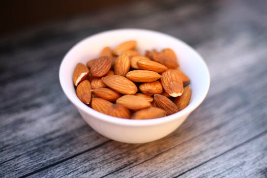 Close-up of organic almonds in a ceramic bowl on wooden table, perfect for food photography.