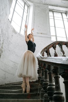 一位芭蕾舞演员在老式螺旋楼梯上优雅地练习，环境优雅