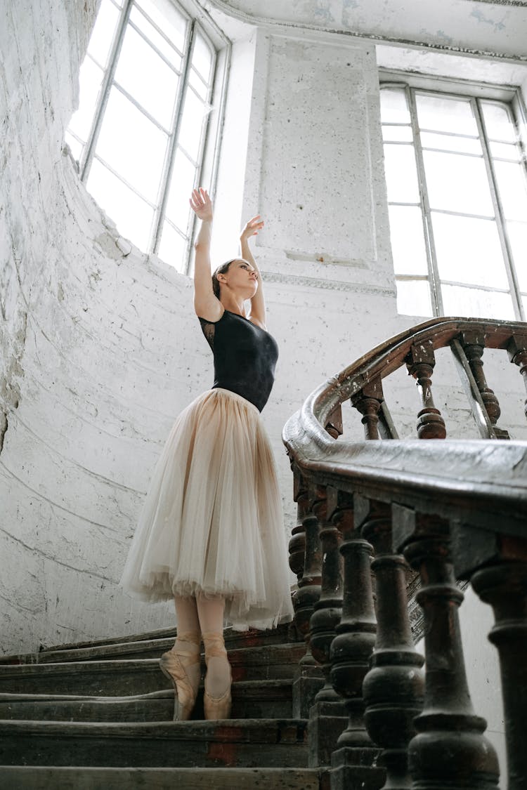 A Woman In Black Tank Top And Tutu Skirt Standing On The Stairs