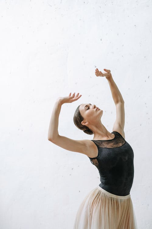 Woman in Black Tank Top Raising Her Hands