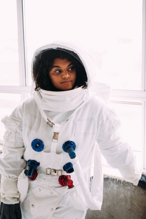 Free Portrait of a woman in a detailed astronaut costume posing indoors, evoking a space exploration theme. Stock Photo
