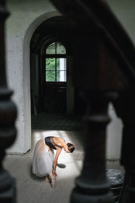 Stunning portrait of a ballerina elegantly posing on tiptoe in an artistic indoor setting.