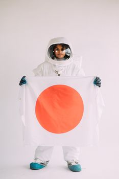 穿着宇航服的人举着日本国旗，象征着国际太空探索