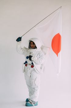 一位穿着全套宇航服的女宇航员举着旗帜，营造万圣节主题