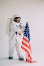 女宇航员在室内穿着全套宇航服与美国国旗合影